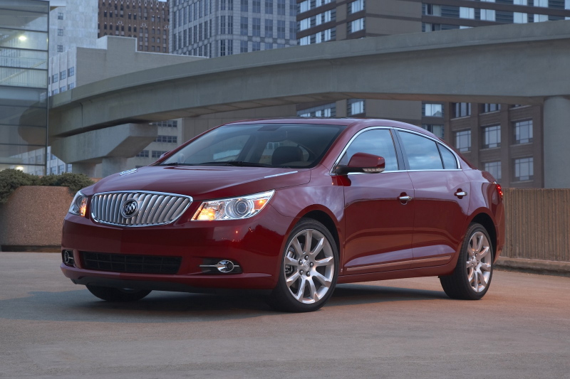 Red 2013 Buick LaCrosse on rooftop garage against downtown buildings